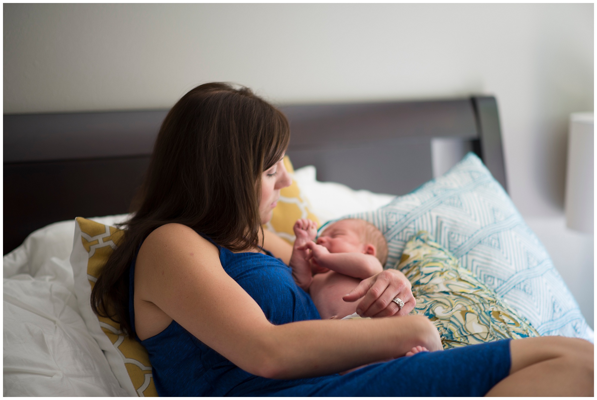 Newborn baby boy in moms arm on bed Emily Ann Photography Seattle