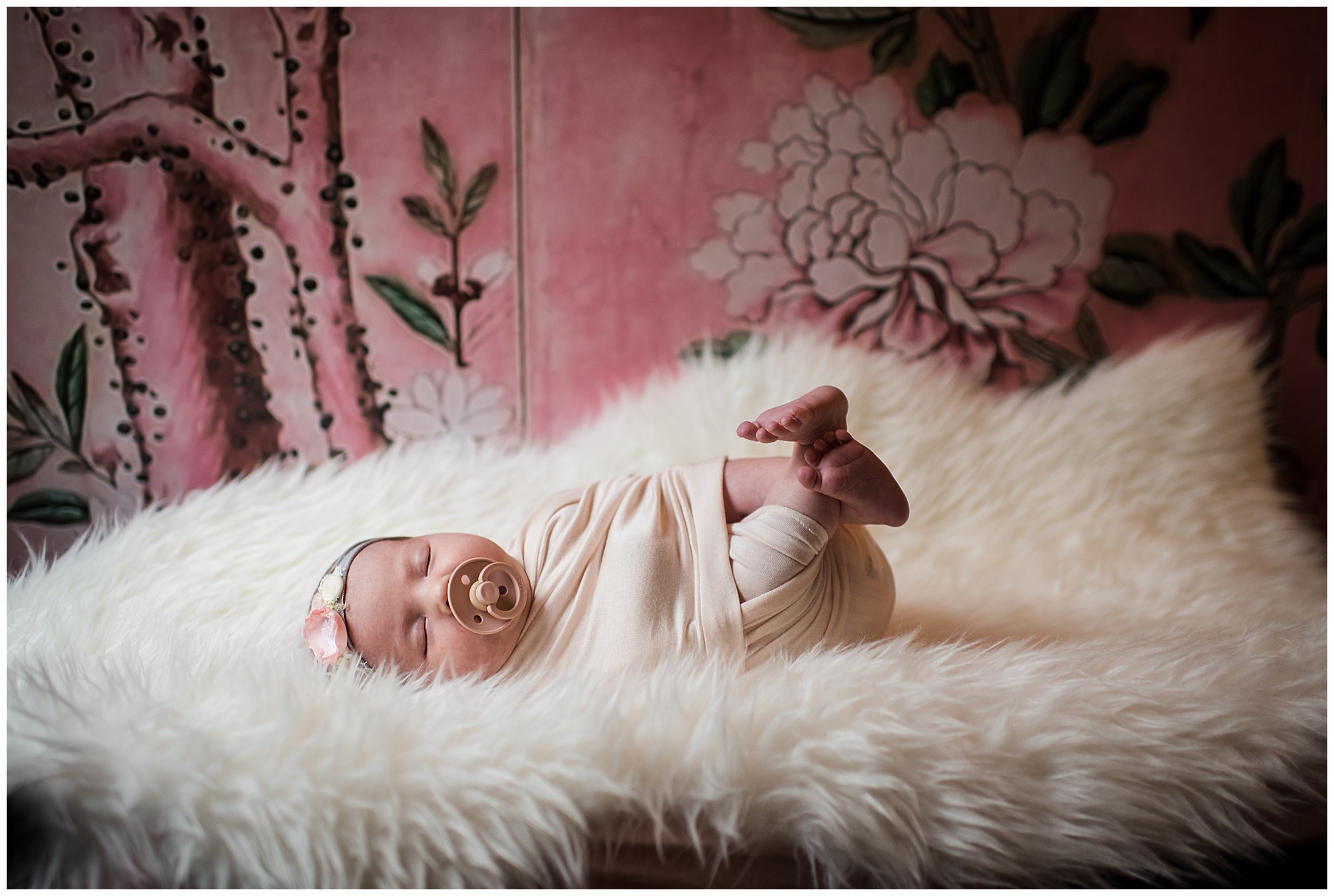 Newborn baby girl on sheepskin with pink floral Magnolia wallpaper Emily Ann Photography Seattle Photographer