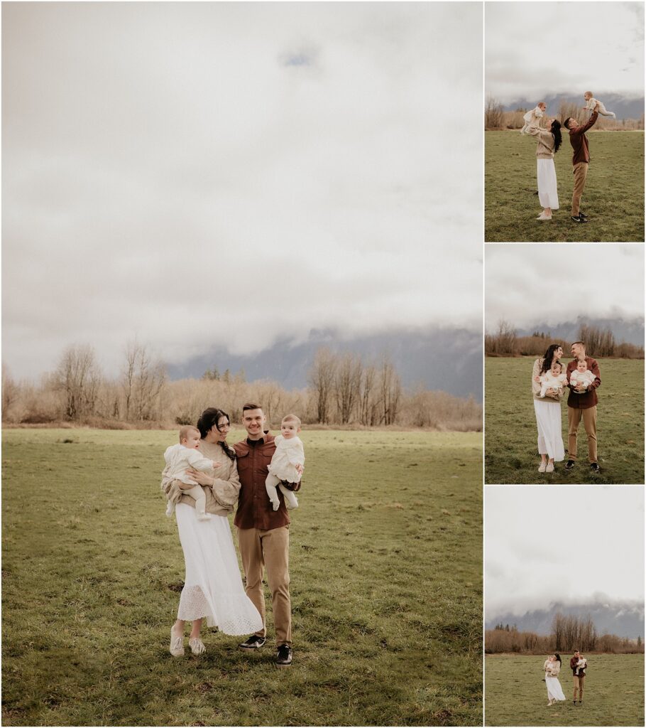 Family of four with twin baby girls play and dance in field with a foggy mountain backdrop